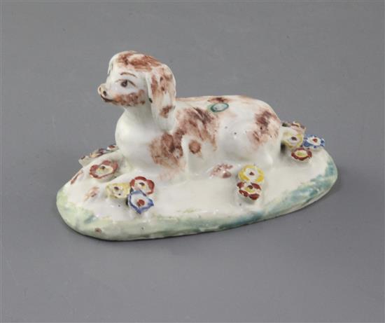 A rare Derby figure of a recumbent spaniel, c.1758-60, l. 9cm, several flowers restored